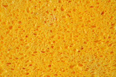 Grafikler için gözenekli sarı-turuncu sünger. Ev yapımı sünger dokularının yakın çekim makro fotoğrafı..