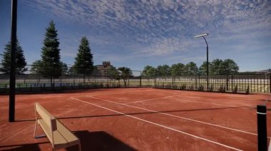 Açık hava tenis kortu canlı kırmızı bir kil yüzey ile süslenmiş, projektörlerle donatılmış ve seyirci banklarıyla kaplanmış.