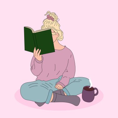 Kız oturuyor ve yerde kitap okuyor.