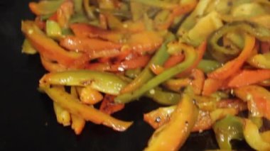 strips of yellow, red and green peppers cooked on the grill. Preparation for restaurant.