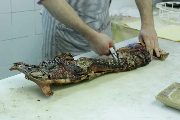 Roasted meat cut by hand with scissors and shears. Restaurant preparation of churrasco and skewers in Sardinian and Brazilian style. Trays full of meat.