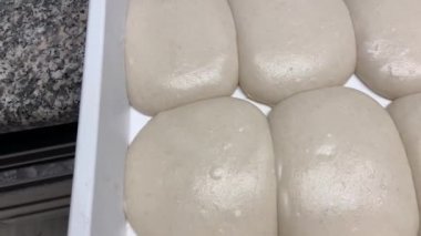 Taze hamurla dolu beyaz kase mükemmelliğe yükseldi. Pizza tezgahının genel görünümü. Yüksek susuzluklu Napoli pizzası. Profesyonel para için en iyi ayrılık.