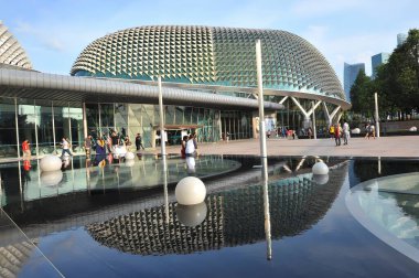 Singapur Körfezi 'ndeki Esplanade Tiyatroları. Yürüyen gökdelenler su yüzeyine yansıyor.