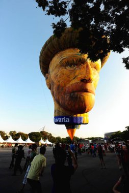 Çok sayıda sıcak hava balonunun olduğu bir festivalde hava gösterisi. Güzel bir günbatımında gökyüzünde yüzen insan yüzünü andıran eşsiz bir tasarım da dahil..