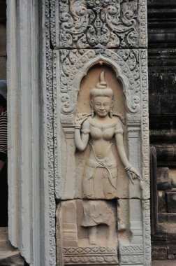 Siem Reap, Kamboçya 'daki Angkor Wat' ın antik duvarlarında yapılan ve geleneksel Khmer sanatının sergilendiği güzel bir heykelin detaylı bir görüntüsü..