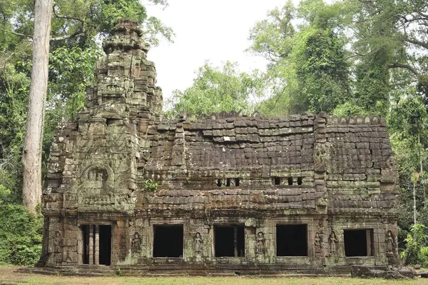 Siem Reap Angkor Wat Kamboçya 'da üzerinde bir sürü yosun olan büyük bir bina. Bina eski ve bir sürü penceresi var.