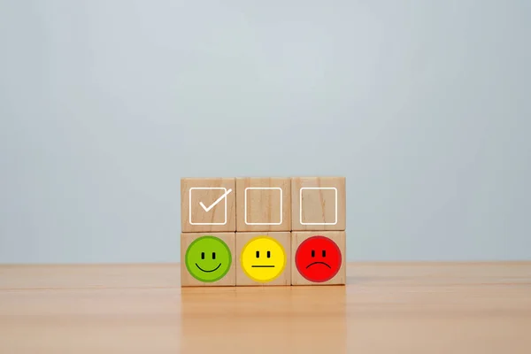 Smile face in bright side and sad face in dark side on wooden block cube for positive mindset selection, Customer experience survey and satisfaction feedback concept.
