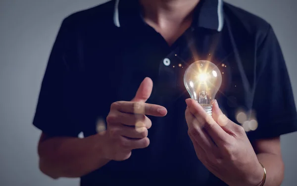 Hand holding a light bulb, concept of ideas for presenting new ideas Great inspiration and innovation new beginning.