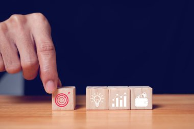 İş adamı veya tüccar analizi ve iş simgeleri, iş hedefleri, başarı hedefleri, iş konsepti içeren tahta bloklar.