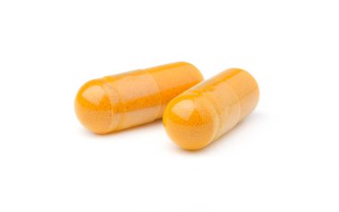 Kapalı zerdeçal bitkisel toz kapsülleri beyaz arka planda izole edildi..