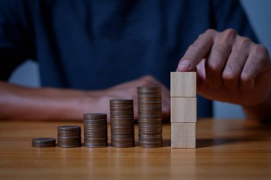  Yatırımcılar, tasarruf finansmanı kavramına sahip madeni paraları büyüyen bir konuma yerleştiriyor, gelecek ve emeklilik için para biriktiriyor.