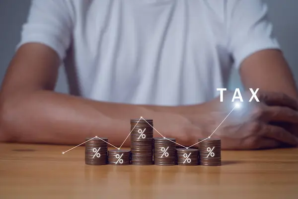 Tax Concept.Word tax and stacked coins put on desks,Tax payment and tax deduction planning.