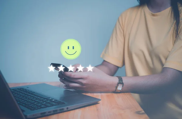 Customer service experience and business satisfaction survey, close up  hand using smart phone and give five star symbol to increase rating of product and service concept.