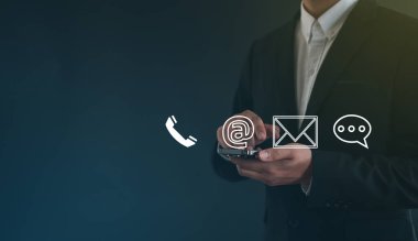  İş adamı sanal ekranda e-posta, adres, telefon, sohbet mesajı simgeleri ile dokunuyor. Müşteri destek hattı Bizimle irtibata geçin.