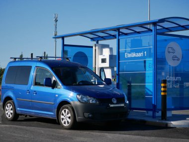 Blue car filling up at Gasum gas station in Finland. High quality photo