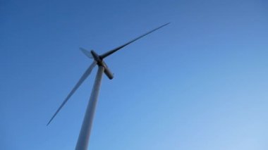 Video of wind turbine from below against a blue sky. High quality 4k footage