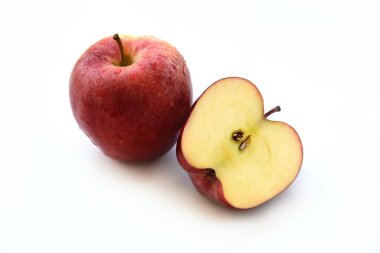 Olgun Elma, bütün meyve ve beyaz arka planda yarım izole edilmiş. Kesik yüzeyde baştan çıkarıcı bir et ve su damlalarıyla kaplı parlak kırmızı bir ten. Sağlıklı organik gıda konsepti.