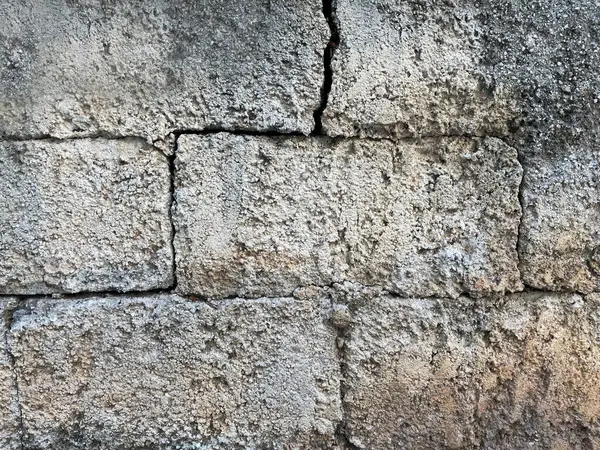 Brick wall texture, closeup of an old exterior surface as a background. Building face wall, convex joint line between dissimilar faded bricks brings character and dimensionality to vintage masonry.