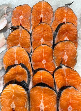 Taze ve çiğ pembe somon balığı markette satılır. Buzda bir sürü balık var, kırmızı balık somondur. Arka plan olarak taze çiğ balık filetosu. Pembe somon, somon balığı ya da alabalık. Sağlıklı yeme kavramı.