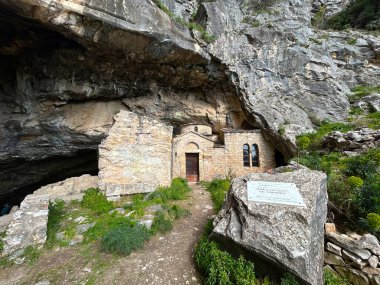 Davelis mağarasında ve Bizans çağının küçük çifte kilisesi doğrudan mağaranın önüne inşa edilmiş, Atina yakınlarındaki Panteli Dağı 'nda saklanıyor, Yunanistan
