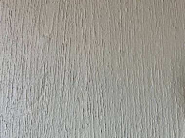 Beton alçının yüzeyi beyaza boyanmış. Arka plan olarak grunge kaba beton dokusu yakın çekim. Dıştaki sıva tabakaları şişmiş. Eski dış duvar çizikler ve çatlaklarla kaplanmış..