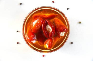 Peynirle doldurulmuş kırmızı dolma biber, yağlı, beyaz arka planda biberli, üst manzara. Sağlıklı yiyecekler. Atıştırmalık.