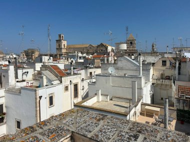 Puglia 'da bir kasaba, güney İtalya' da bir bölge. Beyaz binalar, kırmızı kiremitli çatılar ve birçok anten bu bölgeye özgü. Kilise kuleleri görülebilir, ki bu da tipik bir İtalyan kasabasıdır..