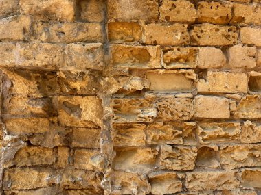 Eski tuğla duvar dokusu, arka plan olarak eski dış yüzeye yakın plan. Binanın ön duvarı, antik çağlardan kalma güllerden oluşan eski tuğlalar. Arkaplan arkaplanı