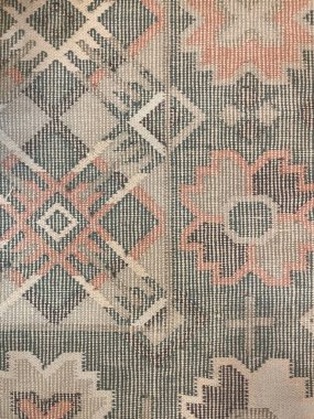 Geometrik ve çiçekli bej, yeşil ve terracotta tonlarında geleneksel dokuma kumaş. Döşeme, halı, moda, iç dekorasyon ve bohem tarzı projeler için kırsal tekstil dokusu.