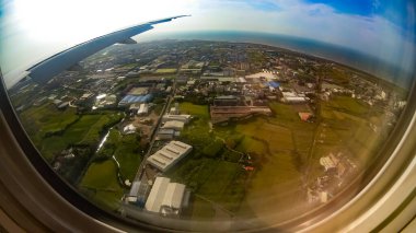 Gökyüzünün balık bakışı görüntüsü. Yukarıdan bak, bir uçak penceresinden. Toprağın tepesinde, bulutlarla ve mavi gökyüzüyle kıta.