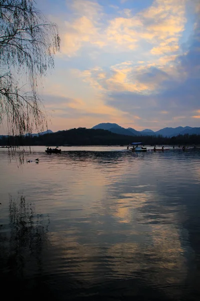 船在平静的海面上航行 背景是日落时分的群山 戏剧化的天空旅行 博客等 西湖杭州人民公园中国 — 图库照片