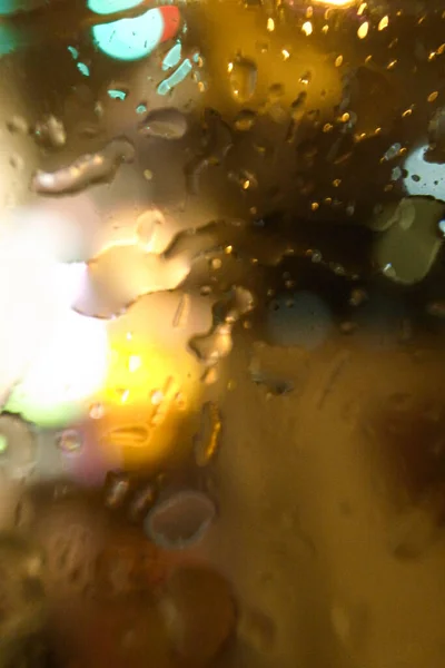 The close-up of raindrops on window at night. For background, for personal blog etc. Blurry effect.