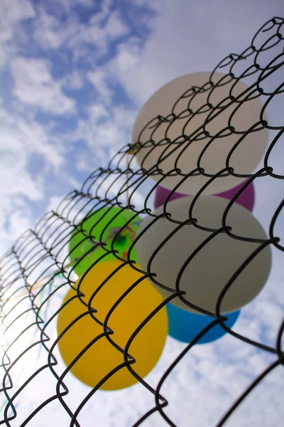 Nahaufnahme Des Zauns Mit Sonnenstrahlen Und Bunten Luftballons Hinter Dem — Stockfoto