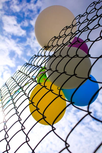 Nahaufnahme Des Zauns Mit Sonnenstrahlen Und Bunten Luftballons Hinter Dem — Stockfoto