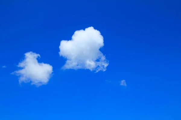 在云层的底部 有两片白色的蓬松的云彩 蓝蓝的天空明亮无比 数码艺术品等 — 图库照片