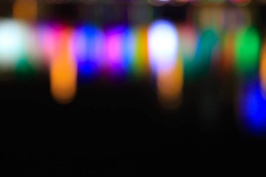 Bokeh etkisi ile geceleri ışığın su yansıması. Renkli bulanık ışık gece suyu yansıtıyor. Odaklanmama etkisi. Arka plan kullanımı için seyahat ve gece sahnesi.