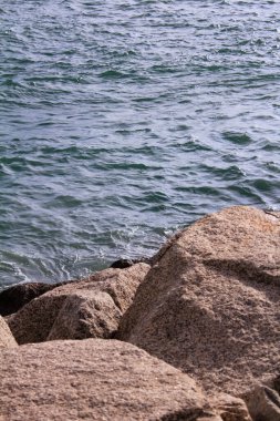 Deniz kenarındaki kayalıklardaki sakin deniz manzarası. Doğa ve seyahat sahnesi. Güneşin altında.