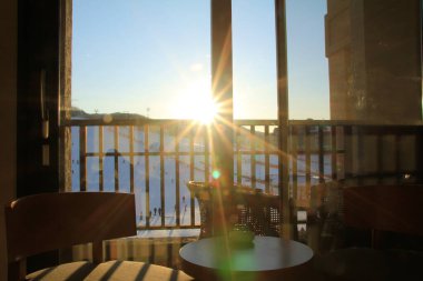 Güneş ışığı, arka plan, pencereden. Dışarıda arka planda kar dağının olduğu boş bir öğleden sonra.. 