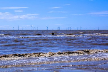 Liverpool, İngiltere 'deki Crosby Sahili' nin mavi gökyüzünün altında 'Başka Bir Yer' heykeli sahnesi. Kuzey Batı İngiltere 'nin Merseyside ilçesinde şehir. Seyahat ve doğa sahnesi.