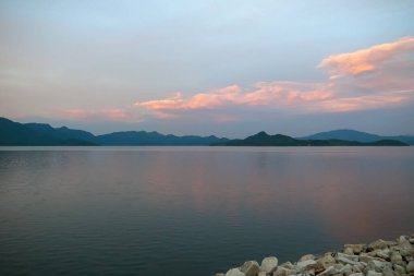 Renkli günbatımının altında sahilin sakin deniz manzarası. Doğa ve Seyahat Sahnesi.