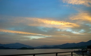 Renkli günbatımının altında sahilin sakin deniz manzarası. Doğa ve Seyahat Sahnesi.