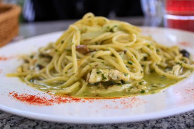 Masadaki pesto makarnasının yakın çekimi. Batı yemek kültürü ve batı mutfağı. Yiyecek konsepti.