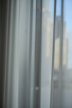 Oteldeki ya da evdeki beyaz perdeleri kapatın. Güneş perdeden ve pencereden parlıyor. İçeriden bakıyorum..