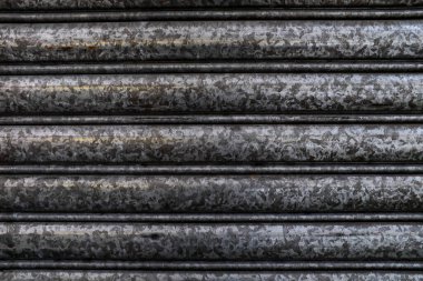 Eski kepenk kapağını kapatın. Kapıda metalik paslı desen deseni var. Arkaplan.