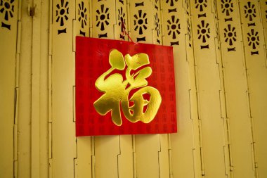 Demir kapı kapısında asılı geleneksel bir Çin takvimi. Dekorasyon için kapıya büyük kırmızı bir takvim asmak için geleneksel uygulama. Çevirisi: Şans.