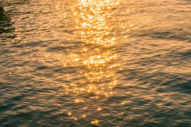 Su üzerindeki altın güneş ışığının yansıması. Işıl ışıl güneş ışığıyla gün batımı deniz manzarası. Gün batımı ışığı okyanusa vuruyor. Günbatımı deniz arkaplanı.