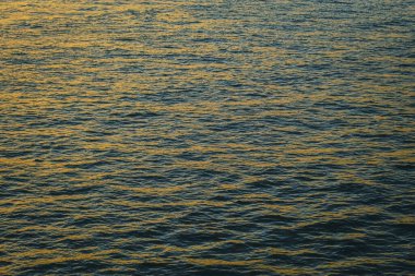 Su üzerindeki altın güneş ışığının yansıması. Işıl ışıl güneş ışığıyla gün batımı deniz manzarası. Gün batımı ışığı okyanusa vuruyor. Günbatımı deniz arkaplanı.