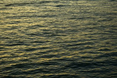 Su üzerindeki altın güneş ışığının yansıması. Işıl ışıl güneş ışığıyla gün batımı deniz manzarası. Gün batımı ışığı okyanusa vuruyor. Günbatımı deniz arkaplanı.