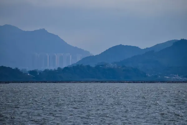 Güneşli bir günde deniz manzarası mavi gökyüzü ve dağ ve arka planda gemiler. Sakin deniz ve su. Deniz arka planı, dalga deseni. Doğa konsepti.