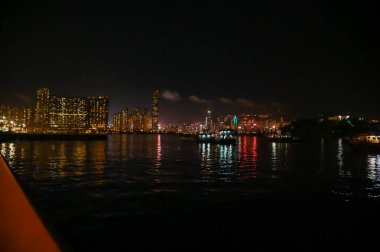 Kowloon 'dan Hong Kong Adası' nın gece manzarası. Geceleri Hong Kong şehir manzarası ve deniz manzarası. Doğa ve şehir manzarası.